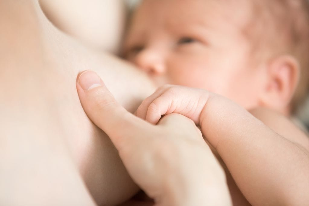 jeune mère qui nourrit son enfant au sein